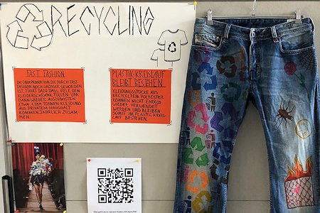 Stellwand mit Infos und einer bunt gestalteten, recyclten Jeans