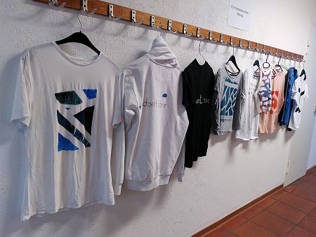 Durch Upcycling gestaltete T-Shirts hängen an einer Garderobe