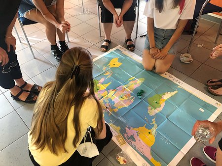 Teilnehmerinnen des Workshops schauen sich einen Weltkarte an