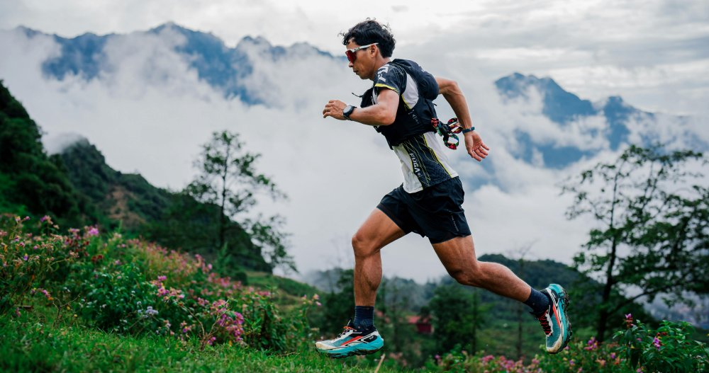 An athlete runs a trail in the mountains.